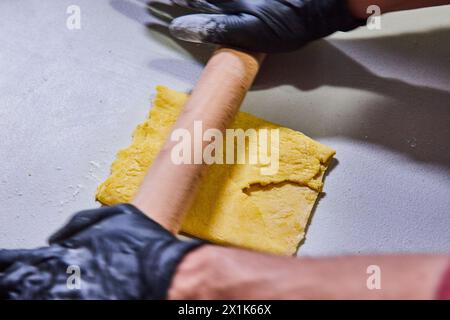 Professioneller Koch, der Teig in der Bäckerei dreht Stockfoto