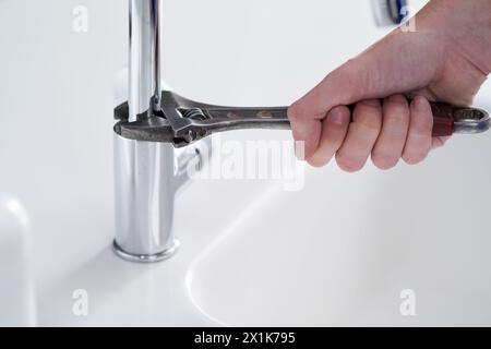 Handwerker, Sanitär und Werkzeuge in Küchenspüle mit Schraubenschlüssel, Rohre und Reparatur bei der Arbeit und Arbeit zu Hause. Männliche Person, Handwerker und Arbeiter für Kunden in Stockfoto