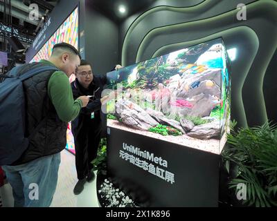 PEKING, CHIAN - 17. APRIL 2024 - Besucher besuchen die „Meta-Universum ökologische Fischtank-Leinwand“ im „Beijing International Audio-Visual Integrated“ Stockfoto