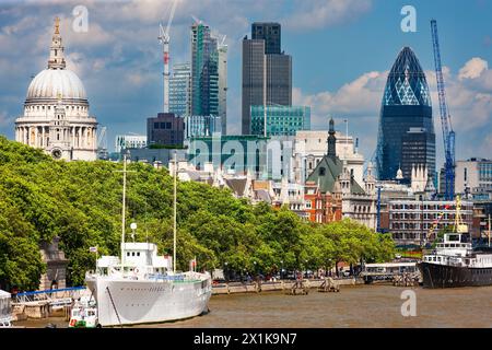 London, Vereinigtes Königreich - 29. Juni 2010 : Themse Nordufer. Das weiße Handelsschiff HQS Wellington aus dem Zweiten Weltkrieg und Bauarbeiten. Stockfoto