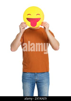 Mann, der das Gesicht mit Emoticon bedeckt, der die Zunge auf weißem Hintergrund hinausragt Stockfoto