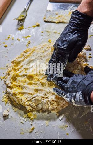 Professioneller Teig mit Handschuhen in der Bäckerei Stockfoto