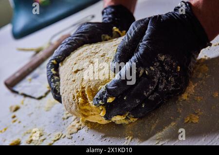 Hausgemachte Teigknete mit Handschuhen, hausgemachte Pasta-Zubereitung Stockfoto