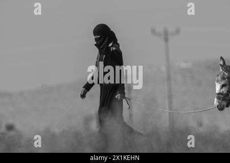 Beduinenmädchen laufen mit einem Esel in der Wüste Stockfoto