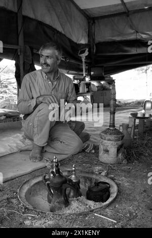 Beduinenmann sitzt in einem Zelt und macht Kaffee Stockfoto