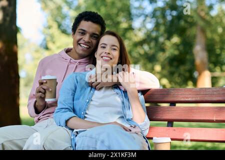 Ein vielseitiges Paar in lebendiger Kleidung sitzt zusammen auf einer Parkbank und genießt die Gesellschaft der anderen in einer ruhigen Umgebung. Stockfoto