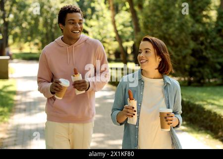 Ein vielseitiges, liebevolles Paar, das in lebendiger Kleidung einen malerischen Gehweg hinuntergeht und sich gegenseitig in Gesellschaft fühlt. Stockfoto