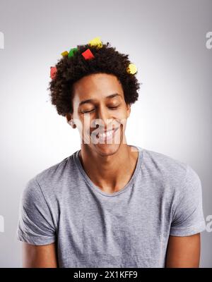 Lächeln, Afro und schwarzer Mann mit Haaren oder Konfetti, Papier und Farbdekoration mit Glück isoliert auf weißem Hintergrund. Männlicher Mensch, Gen z Guy und Stockfoto