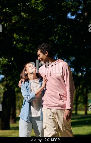Ein vielseitiges Paar, lebhaft gekleidet, schlendert durch einen friedlichen Park und genießt die Gesellschaft der anderen. Stockfoto