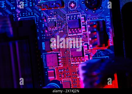 Lebendige Motherboard-Schaltkreise in Nahaufnahme mit blauer und roter Beleuchtung Stockfoto