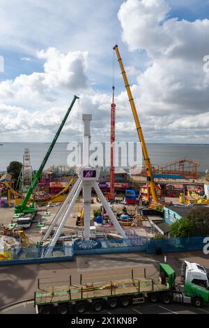 Kräne vor Ort im Vergnügungspark Adventure Island heben den neuen Vertigo 38 Meter Tower Ride in Position. Fallturm Stockfoto