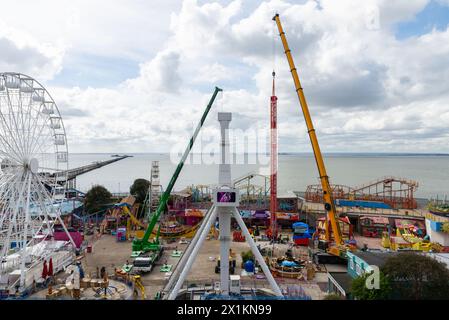 Kräne vor Ort im Vergnügungspark Adventure Island heben den neuen Vertigo 38 Meter Tower Ride in Position. Fallturm Stockfoto