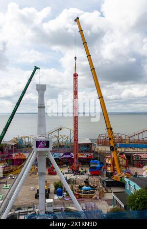 Kräne vor Ort im Vergnügungspark Adventure Island heben den neuen Vertigo 38 Meter Tower Ride in Position. Fallturm Stockfoto