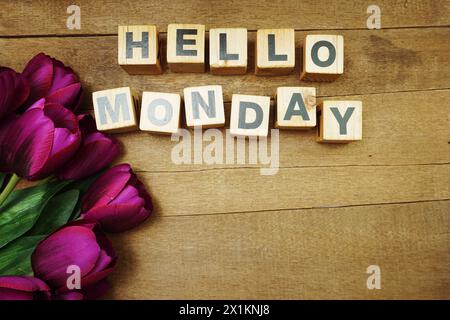 Hallo Montag Buchstaben mit Tulpenblütenstrauß auf hölzernem Hintergrund Stockfoto