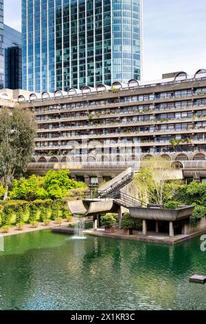 Ein Wasserfall am Barbican Estate Pond mit Willoughby House im Hintergrund, London, England Stockfoto