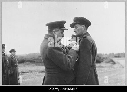 AIR CHIEF MARSHAL SIR SHOLTO DOUGLAS SCHMÜCKT ZWEI TSCHECHOSLOWAKISCHE OFFIZIERE - Bild (ausgestellt 1944) Shows - Air Chief Marshal Sir Sholto Douglas schmückt einen tschechoslowakischen Offizier, Mitglied der tschechoslowakischen Crew, der am 27. Dezember 1943 mit dem D.F.C den deutschen Blockadeläufer in der Bucht von Biskaya versenkte, Royal Air Force Stockfoto