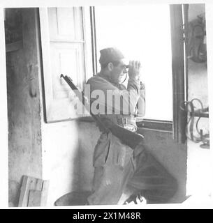 ITALIEN : ACHTE ARMYRIVER SANGRO SCHLACHT - an einem Aussichtsposten mit Blick auf den Fluss Sangro, Pte. Tom Gover von 6 Inf. BDE., 2. Neuseeländische Division, aus Chakune, N.Z. blickt durch sein Fernglas, während die RAF die deutschen Positionen am Nordufer des Flusses bombardiert, britische Armee Stockfoto