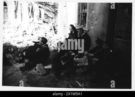 AFS FILM ACTORS: THE FILMING OF 'UNPUBLISHED STORY' IN DENHAM FILM STUDIOS, DENHAM, BUCKINGHAMSHIRE, ENGLAND, GROSSBRITANNIEN, 1941: Männer der Uxbridge Fire Brigade sitzen zwischen Trümmern und Trümmern am Set und beobachten die Action, die sich um sie herum entfaltet, während der Dreharbeiten des Films „Unpublished Story“ der Two Cities Film Company in den Denham Film Studios in Buckinghamshire. Regie führte Harold French und die Hauptrollen Richard Greene und Valerie Hobson. Es spielt während des Blitz auf den Londoner Docks im Jahr 1940, Stockfoto