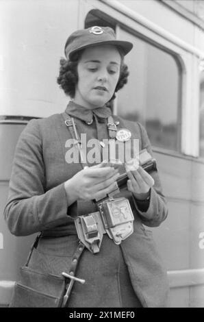 LONDON BUSES IN KRIEGSZEITEN, ENGLAND, 1941 – die Londoner Busleiterin Lilian Menhenett prüft ihre Tickets am Busbahnhof, bevor sie den Tag beginnt. Dieses Foto wurde wahrscheinlich im September 1941 aufgenommen. Stockfoto