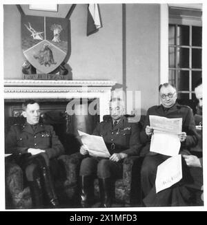 General Gustaw Paszkiewicz und andere hochrangige Offiziere der 1st Rifle Brigade lasen das Nachrichtenblatt in der Offizierslounge in Cupar, Schottland, und zeigten das Wappen des Burgh of Biggar. Stockfoto