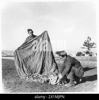 ALBANIEN: "HINTERZIMMER-JUNGS" AN DER VORDERSEITE - C.R.Rogers (Royal Signals) von Weybridge, Surrey, Signalgeber, unterstützt von einem Partisanen, der einen Fallschirm rettet. Rogers erhielt die Tapferkeitsmedaille und einen Freipass für die UdSSR für seine Arbeit in Jugoslawien, der britischen Armee Stockfoto