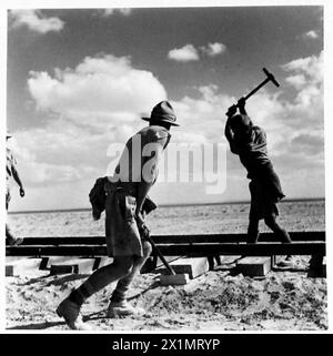 BILDER AUS DER Western DESERTRAILWAY-KONSTRUKTION - nachdem die Schienen in Position gebracht wurden, werden die Stifte eingeschoben, um die Schiene in Position zu halten, British Army Stockfoto