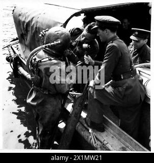 DER BBC-KRIEGSKORRESPONDENT MACHT UNTERWASSERAUFNAHMEN - Ein Taucher lässt seinen Helm anpassen und Aufzeichnungen, bevor er auf den Meeresboden abgesenkt wird, British Army Stockfoto