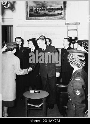 Die PRINZESSIN ROYAL TRIFFT ALLIIERTE MITARBEITER IM CHURCHILL CLUB - H.R.H. die Prinzessin Royal besuchte den Churchill Club in London am 12. Dezember 1944 und traf viele Männer und Frauen aus dem Dominion und den alliierten Ländern. Der Churchill Club wurde gegründet, um ein besseres Verständnis zwischen den Soldaten Großbritanniens, der Dominions und der Alliierten zu fördern. Das Bild (ausgestellt 1944) zeigt: H.R.H. die Prinzessin Royal schüttelt die Hand mit Flight Lieutenant A.W. Roper von der Royal Australian Air Force in Sydney, New South Wales. Er ist ein ehemaliger US-amerikanischer Cricketspieler in New South Wales, der nach einer sportart arbeitete Stockfoto