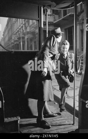 Ein TAG IM LEBEN Einer HAUSFRAU AUS KRIEGSZEITEN: ALLTAG IN LONDON, ENGLAND, 1941 - Mrs Day wird von einer Schaffnerin im Bus unterstützt, der sie zur Arbeit bringt. Dieses Foto wurde wahrscheinlich an der Fulham Road aufgenommen. Stockfoto