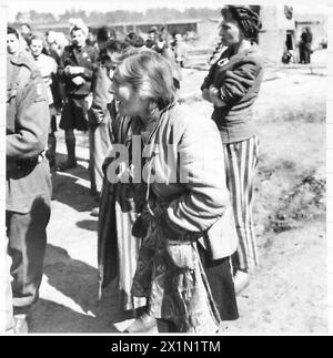 DIE BEFREIUNG DES KONZENTRATIONSLAGERS BERGEN-BELSEN, APRIL 1945 – Hela wurde in einer jüdischen Familie in Tuszyn in Zentralpolen geboren, was vier Jahre in Konzentrationslagern bedeutete. Sie war im Ghetto Łódź (Litzmannstadt), Auschwitz und Bergen-Belsen (nur zwei Wochen vor der Ankunft der britischen Truppen in Belsen). HeLa Goldstein, eine polnische Häftlinge, und andere weibliche Gefangene, die SS-Wärter beobachteten, die erschöpft beim Verladen von Lastwagen mit Leichen toter Häftlinge fielen, 21. April 1945, Goldstein, Helena Stockfoto