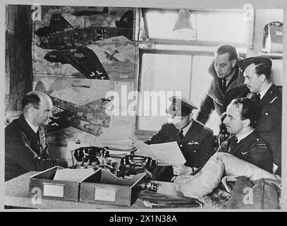 FINDEN SIE DEN FEIND, SCHLAGEN SIE DEN FEIND AN, SCHÜTZEN SIE DIE SCHIFFFAHRT, DIE DREIFACHE AUFGABE DES KÜSTENKOMMANDOS. - 5955 Coastal Command Intelligence Officer verhört eine Crew. (Bild aus dem Jahr 1943), Royal Air Force Stockfoto