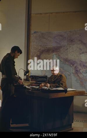 Generalleutnant W.D. Morgan, Stabschef von Feldmarschall Alexander, Überprüfung einer Mittelmeerkarte im AFHQ Caserta, Italien, März 1945. Stockfoto