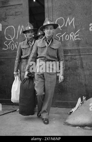 NEUSEELAND-REPATRIATES KOMMEN NACH ENGLAND: ALLTAG FÜR REPATRIIERTE KRIEGSGEFANGENE IN MARGATE, KENT, ENGLAND, Großbritannien, APRIL 1945 - die Neuseeländer L R Tucker und W R Rennell verlassen den Quartermaster's Store in Margate, nachdem sie komplett mit neuseeländischer Kleidung ausgestattet wurden. Beide haben brandneue Kit-Taschen, Stockfoto