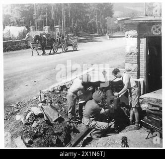 ACHTE ARMEE: JETZT LEBEN DIE TRUPPEN WIRKLICH - Männer des Panzerabwehrregiments 67, R.A., bemannen ihre Waffe ständig auf der Straßenkreuzung in Comeno. Ein jugoslawisches Pferdefahrzeug wird an ihnen vorbeigeführt, British Army Stockfoto