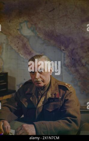 Generalleutnant W. D. Morgan, Stabschef von Feldmarschall Alexander, wird während der Operationen der britischen Armee im März 1945 an seinem Schreibtisch vor einer Karte des Mittelmeers im AFHQ in Caserta, Italien, gezeigt. Stockfoto