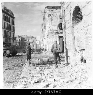 ITALIEN: 8. ARMEEEINTRITT IN ORTONA - Infanterie-Scharfschützen unter Panzern, in der Hauptstraße, British Army Stockfoto