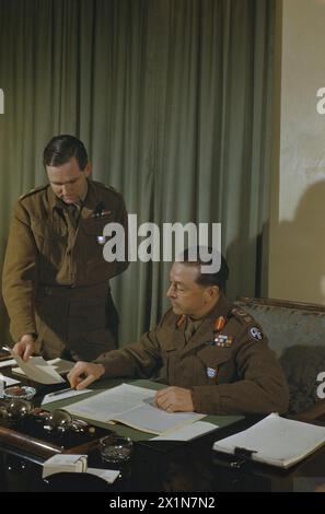 Feldmarschall Sir Harold Alexander, Oberster alliierter Befehlshaber der Mittelmeerstreitkräfte, wird mit einem Helfer an seinem Schreibtisch in seinem Hauptquartier im Königspalast in Caserta, Italien, abgebildet. Stockfoto