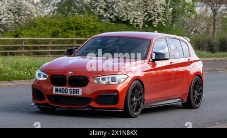 Milton Keynes, Großbritannien - 14. April 2024: 2015 orangefarbenes BMW 1er M135i Auto auf einer britischen Straße Stockfoto