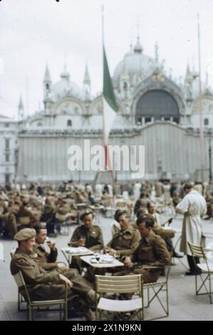 SOLDATEN DER BRITISCHEN ARMEE AUF URLAUB IN VENEDIG, ITALIEN, JUNI 1945 - Corporal T Fenn, aus Mottingham, London; Private E W Jones aus Esher, Surrey; Private W J Leaman aus Ashburton, Nr Newton Abbot, Devon; Private A Clark aus St Johns, Deptford, London; und privater G C Foreman of Warminster, Wiltshire, in einem Open-Air-Café auf der Piazza San Marco. Die berühmte Kirche ist im Hintergrund, British Army Stockfoto