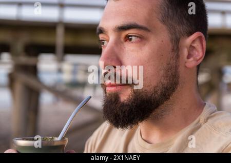 Mann trinkt chimarrão, Mate (eine Infusion von Yerba Mate mit heißem Wasser) bei Sonnenuntergang in uruguay Stockfoto
