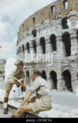 DIE BRITISCHE ARMEE AUF URLAUB IN ITALIEN, JUNI 1944 - "A Day in Rome with Gunner Smith": Gunner Smith vor dem Kolosseum hält mit einem Freund inne, um den Reiseführer British Army zu konsultieren Stockfoto