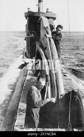 ROYAL NAVY 1939 - 1945: U-BOOTE Robin Harbud und Sgt Ernest Cooke mangeln ihr Kanu, das für die COPP-Piloten eingesetzt wird, durch die vordere Luke eines U-Bootes, Stockfoto