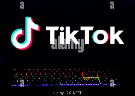 In dieser Abbildung wird das TikTok-Logo auf dem Computerbildschirm mit einer Tastatur mit farbigen Lichtern angezeigt. Stockfoto