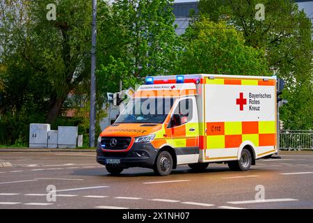 Augsburg, Bayern, Deutschland - 17. April 2024: Ambulanz des Bayerischen Roten Kreuzes fährt mit Blaulicht durch die Stadt zu einem Rettungseinsatz *** Rettungswagen des Bayerischen Roten Kreuzes fährt mit Blaulicht durch die Stadt zu einem Rettungseinsatz Stockfoto