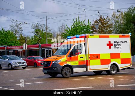 Augsburg, Bayern, Deutschland - 17. April 2024: Ambulanz des Bayerischen Roten Kreuzes fährt mit Blaulicht durch die Stadt zu einem Rettungseinsatz *** Rettungswagen des Bayerischen Roten Kreuzes fährt mit Blaulicht durch die Stadt zu einem Rettungseinsatz Stockfoto