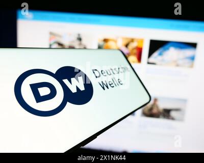 Mobiltelefon mit Logo der Deutschen Welle (DW) vor der Website. Fokus auf der linken Seite des Telefondisplays. Stockfoto