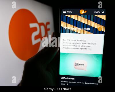 Person mit Smartphone mit Webseite des zweiten Deutschen Fernsehens (ZDF) mit Logo. Konzentrieren Sie sich auf die Mitte des Telefondisplays. Stockfoto