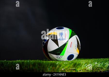 HAMBURG, DEUTSCHLAND, 17. APRIL 2024: Offizielle Adidas Fußball Fußball Fussballliebe für die EM 2024, platziert auf grünem Gras. Schwarzer Hintergrund Stockfoto