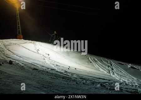 St. Peter, Deutschland. April 2024. Ein Skifahrer wird von der Kaibenloch-Lift auf eine Skipiste gezogen. Die Wintersportsaison im Schwarzwald endete vor Wochen. Nach sommerlichen Temperaturen auf dem Schwarzwaldgipfel der Kandel kehrte Mitte April der Winter zurück - mit viel Neuschnee. Ab Mittwochabend öffnen die Kandellifte und bieten Flutlichtantrieb für Skifahrer und Snowboarder. Quelle: Philipp von Ditfurth/dpa/Alamy Live News Stockfoto