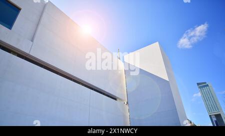 Sonnenlicht und Schatten auf der Oberfläche von weißem Beton Gebäudewand vor blauem Himmel Hintergrund, geometrische Außenarchitektur in Minimal Street Photogra Stockfoto